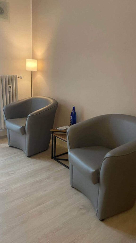 Due poltrone beige posizionate l'una a fianco all'altra in uno studio di terapia di coppia